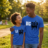 Black father and son wearing matching blue Big Drip and Lil Drip shirts in a park
