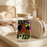 Clear 100% That B*tch glass with illustrated Black woman, bamboo lid and glass straw styled on a vanity tray.
