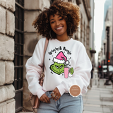 Woman wearing a white sweatshirt with a graphic design, standing on a city street.